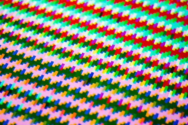 Angled close-up of a print's diagonal rows of tiny multicoloured stepped blocks.