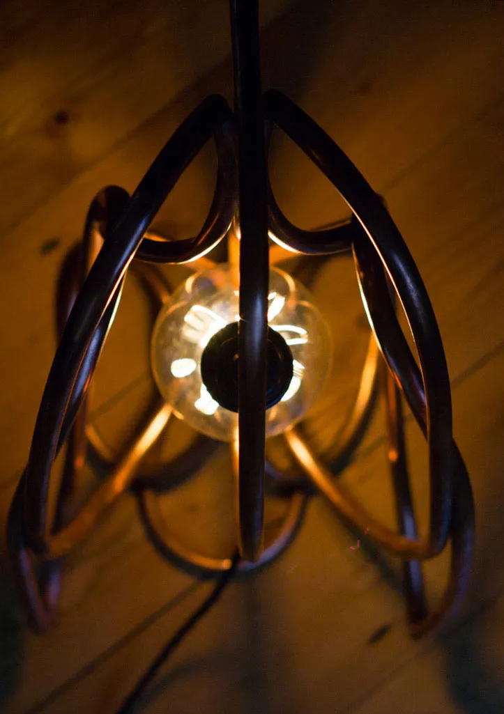 The lamp seen from directly above, with the spine pipe running over the bulb and the wing loops spread either side.