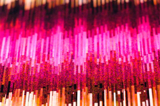 Close-up of a print's vertical pink, orange, and dark red streaks, softly out of focus.