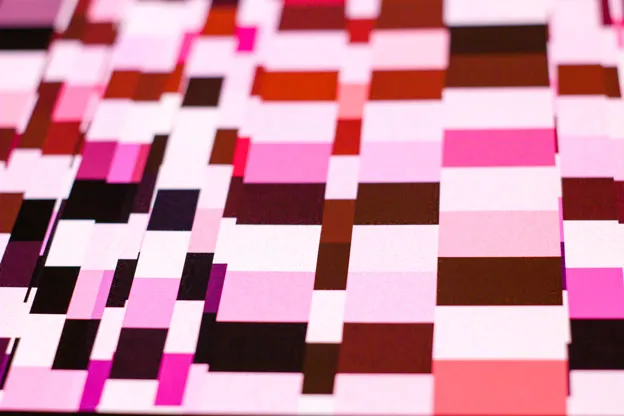 Close-up of a print's grid of pale pink, maroon, and dark brown rectangles.