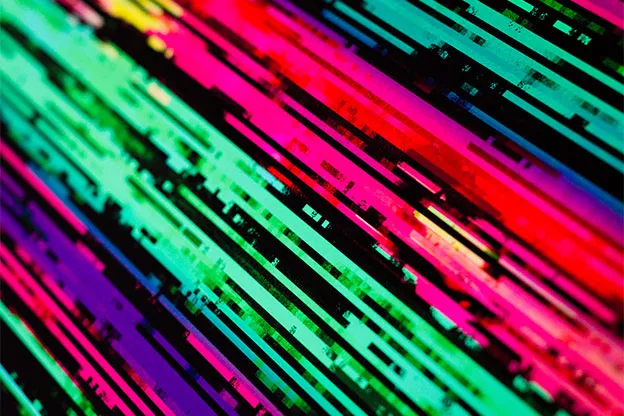 Close-up of a print's diagonal green, pink, and red streaks on black.